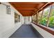 Covered patio featuring natural wood beams and white brick with access to the main house at 18906 Crescent Rd, Odessa, FL 33556