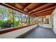 Covered patio featuring natural wood beams and white brick with views of the well manicured backyard at 18906 Crescent Rd, Odessa, FL 33556