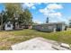 Spacious backyard with mature tree, shed, and concrete patio, perfect for outdoor enjoyment at 2166 Dixie Garden Loop, Holiday, FL 34690