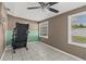 Multi-tone bedroom with a treadmill, tiled floor, and bright windows at 2166 Dixie Garden Loop, Holiday, FL 34690