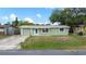 Charming one-story home with a well-maintained lawn and neutral-colored exterior under a clear blue sky at 2166 Dixie Garden Loop, Holiday, FL 34690