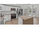Contemporary kitchen with white cabinets, stainless steel appliances, and an island with granite countertop at 2166 Dixie Garden Loop, Holiday, FL 34690