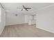 Open-concept living area with wood-look flooring, a ceiling fan, and a view into the kitchen at 2166 Dixie Garden Loop, Holiday, FL 34690