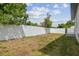 Backyard featuring a white picket fence, expansive lawn, and mature trees, perfect for outdoor enjoyment at 2305 W Kentucky Ave, Tampa, FL 33607
