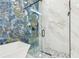 Luxurious shower featuring blue and gold marble-style tile and glass door at 2305 W Kentucky Ave, Tampa, FL 33607