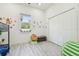 Bright bedroom featuring modern gray floors, playful wall decor, and ample natural light at 2305 W Kentucky Ave, Tampa, FL 33607