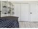 Neutral bedroom features grey flooring, a comfortable bed, and a white shelving unit with ample storage space at 2305 W Kentucky Ave, Tampa, FL 33607