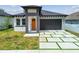 New construction home featuring a modern design, neutral paint, and front yard landscaping at 2305 W Kentucky Ave, Tampa, FL 33607