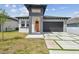 New construction home featuring a modern design, neutral paint, landscaping, and a front yard at 2305 W Kentucky Ave, Tampa, FL 33607