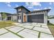 New construction home featuring a modern design, neutral paint, and front yard landscaping at 2305 W Kentucky Ave, Tampa, FL 33607