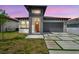 Modern home with striking curb appeal featuring a unique architectural design and orange front door at 2305 W Kentucky Ave, Tampa, FL 33607