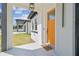 Home featuring an orange front door, stylish hardware, and modern porch lighting at 2305 W Kentucky Ave, Tampa, FL 33607