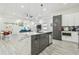 Bright kitchen has white cabinets, a gray island and appliances, and an open floor plan at 2305 W Kentucky Ave, Tampa, FL 33607