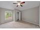 Neutral bedroom features standard closet, ceiling fan, and window view of neighborhood at 2512 Clubhouse Dr, Plant City, FL 33566