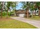 Inviting home with a two-car garage, a basketball hoop, a screened in porch, and mature trees at 2512 Clubhouse Dr, Plant City, FL 33566