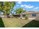 View of back of house, screened-in patio, mature trees, and well-manicured lawn at 2961 Stockwood Dr, Clearwater, FL 33761