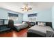 Light and airy bedroom featuring twin beds, wood flooring, and a ceiling fan at 2961 Stockwood Dr, Clearwater, FL 33761