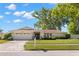 Charming single-story home featuring a well-manicured lawn, mature trees, and an attached two-car garage at 2961 Stockwood Dr, Clearwater, FL 33761