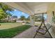 Charming front porch with brick flooring, swing and a peaceful view of the green lawn at 2961 Stockwood Dr, Clearwater, FL 33761