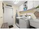 Well-lit laundry room with washer, dryer, utility sink, and ample storage cabinets at 2961 Stockwood Dr, Clearwater, FL 33761
