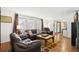 Bright and airy living room with hardwood floors and plush leather seating with view of stained glass front door at 2961 Stockwood Dr, Clearwater, FL 33761