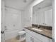 Bathroom features a granite countertop, tiled floor and shower-tub combo at 30752 Veridian Way, Wesley Chapel, FL 33545