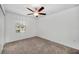 Bedroom features plush carpeting, ceiling fan, and large window for natural light at 30752 Veridian Way, Wesley Chapel, FL 33545