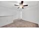 Upstairs bedroom features neutral carpet, a ceiling fan, and a hallway at 30752 Veridian Way, Wesley Chapel, FL 33545
