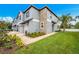 Desirable townhome featuring a two-car garage, lush lawn, and stone detailing at 30752 Veridian Way, Wesley Chapel, FL 33545