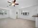 Bright living room features neutral tile flooring, ceiling fan, and natural light from the windows and back door at 30752 Veridian Way, Wesley Chapel, FL 33545