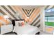 Chic bedroom featuring a striking geometric accent wall, neutral tones, and modern furnishings at 3213 Lumber Falls Dr, Plant City, FL 33565