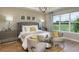 Comfortable main bedroom featuring a tufted headboard, soft lighting, and a view of the outdoors at 3213 Lumber Falls Dr, Plant City, FL 33565