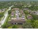 Real estate aerial view shows buildings with covered parking, road with crosswalks and mature trees at 3540 Countrybrook Ln # 23, Palm Harbor, FL 34684