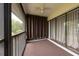 Enclosed balcony features neutral carpeting, curtain privacy, and a ceiling fan at 3540 Countrybrook Ln # 23, Palm Harbor, FL 34684
