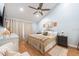 Bedroom with a ceiling fan, neutral color palette, wood floors, and a comfortable bed at 3540 Countrybrook Ln # 23, Palm Harbor, FL 34684