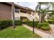 Inviting two-story condo entrance with a sidewalk and lush landscaping at 3540 Countrybrook Ln # 23, Palm Harbor, FL 34684