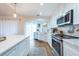 Updated kitchen with white cabinetry, stainless steel appliances, and an oversized white countertop island at 3540 Countrybrook Ln # 23, Palm Harbor, FL 34684