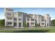 Beautiful exterior elevation of new construction townhomes with spacious balconies and charming architectural detail at 3576 Silent Gardens Cv, Wesley Chapel, FL 33543