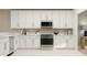 Contemporary kitchen with stainless steel appliances, white cabinetry, and granite countertops for a sleek, modern design at 3576 Silent Gardens Cv, Wesley Chapel, FL 33543