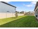 Grassy backyard with a secure privacy fence and young trees planted along the property line at 4365 Frontera Ln, Wesley Chapel, FL 33543