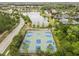 Aerial view of a community basketball court alongside a scenic pond and lush landscaping in a residential neighborhood at 4365 Frontera Ln, Wesley Chapel, FL 33543