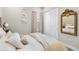 Bedroom showcasing a bed, closet, a decorative mirror and neutral color palette at 4365 Frontera Ln, Wesley Chapel, FL 33543