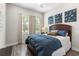 Comfortable bedroom with a wood-framed bed and three pane windows with white blinds at 4365 Frontera Ln, Wesley Chapel, FL 33543