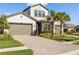 Charming two-story home boasting a three car garage, stone accents, and manicured landscaping at 4365 Frontera Ln, Wesley Chapel, FL 33543