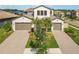 Beautiful two-story home featuring a three-car garage, brick driveway, and lush landscaping at 4365 Frontera Ln, Wesley Chapel, FL 33543