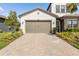 Three-car garage with brick paved driveway and well-maintained landscaping at 4365 Frontera Ln, Wesley Chapel, FL 33543