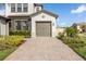 A close up view of the garages with well-manicured landscaping at 4365 Frontera Ln, Wesley Chapel, FL 33543