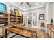 Office with bookshelves and a table leading to an upstairs with stairs and french doors at 4365 Frontera Ln, Wesley Chapel, FL 33543