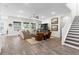 Bright living room features hardwood floors, large windows, and a staircase to the second level at 4365 Frontera Ln, Wesley Chapel, FL 33543