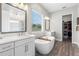 Elegant main bathroom with double vanity, soaking tub, a separate shower, and a walk-in closet at 4365 Frontera Ln, Wesley Chapel, FL 33543